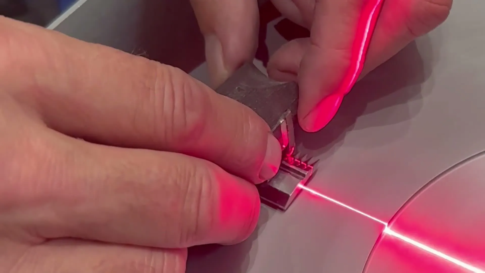 Rezilo strojčka za striženje z rdečo lasersko črto na ravni brusni plošči.